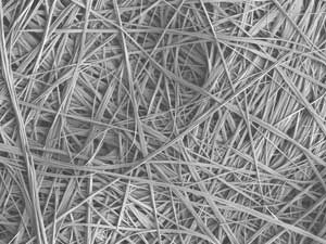 As the nanofibers form, they trap crude oil in a tangled net that floats above the water.